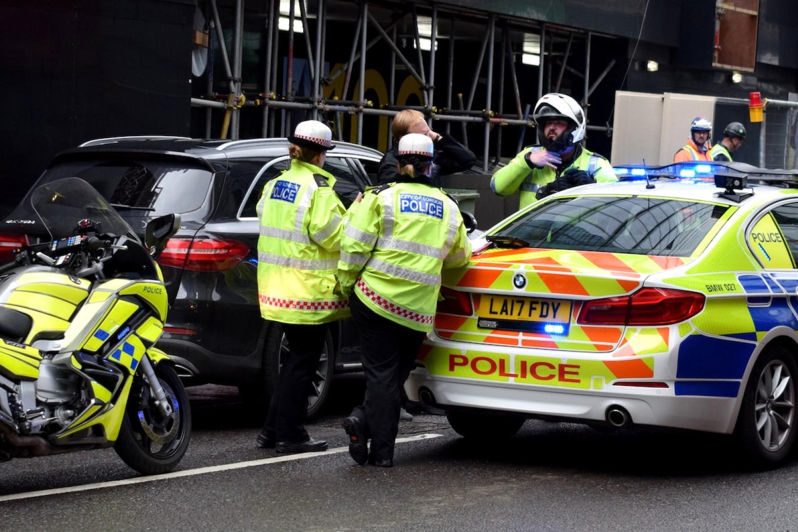 Police Officers leaning on a police car
